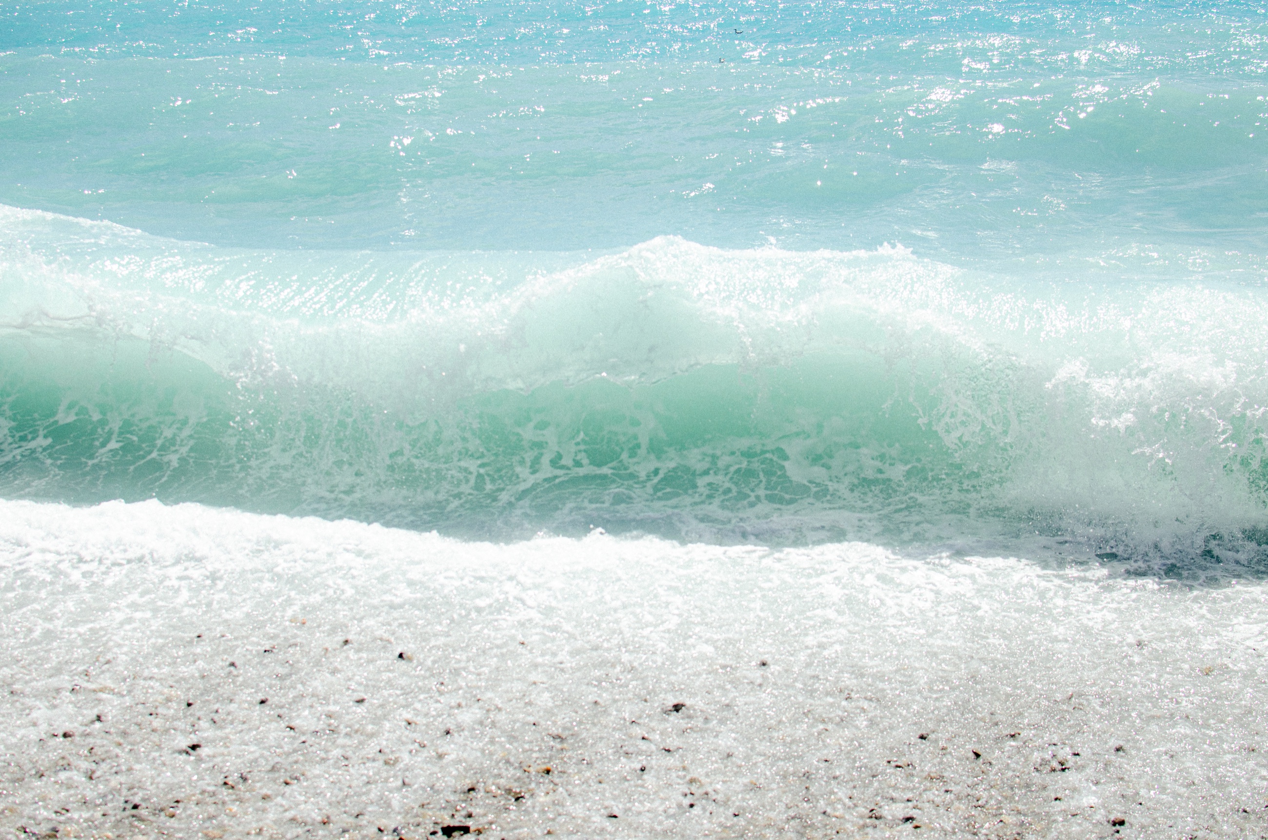 Vague turquoise sur les galets de Nice