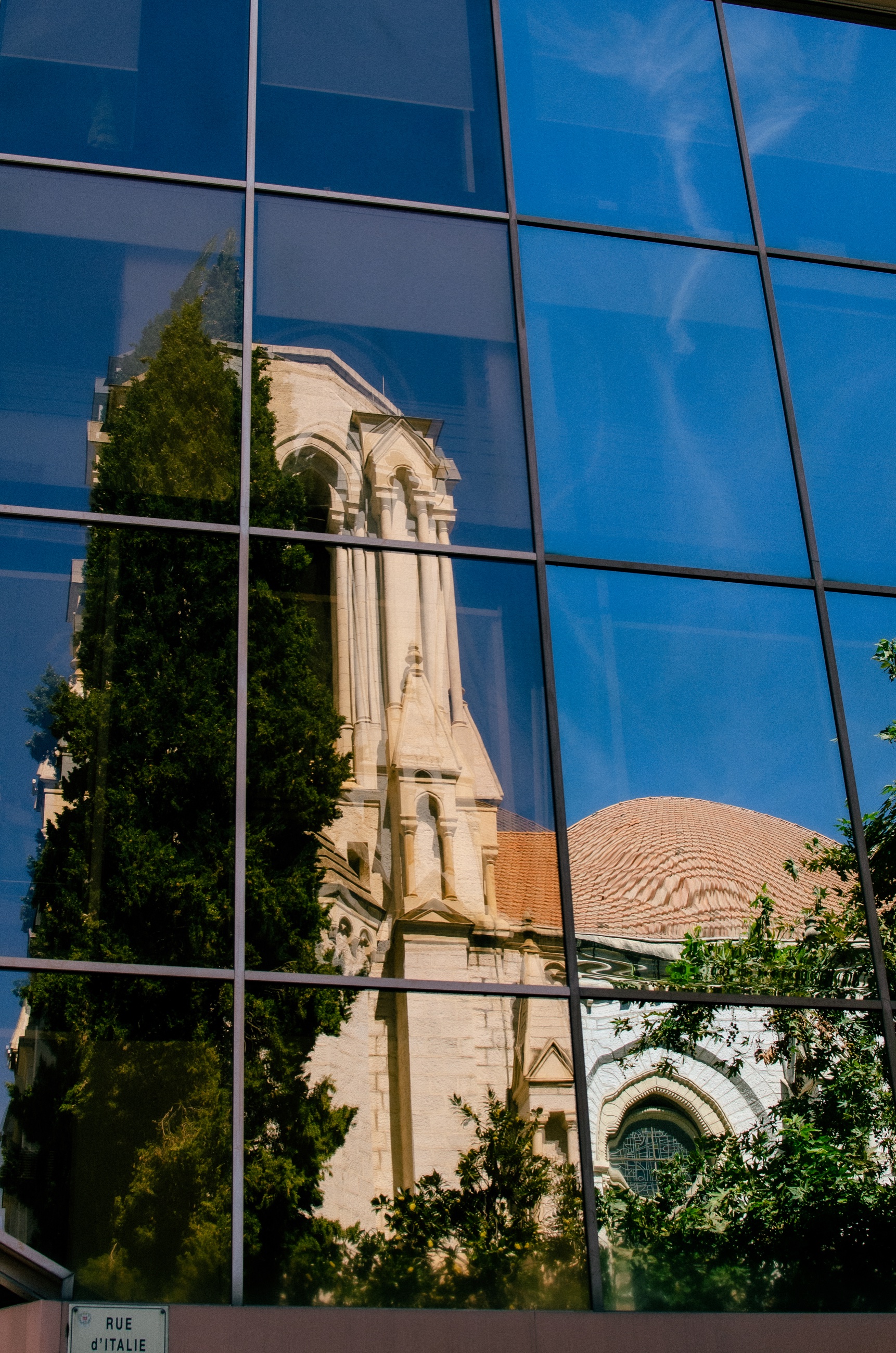 Reflet d’église dans une façade vitrée à Nice