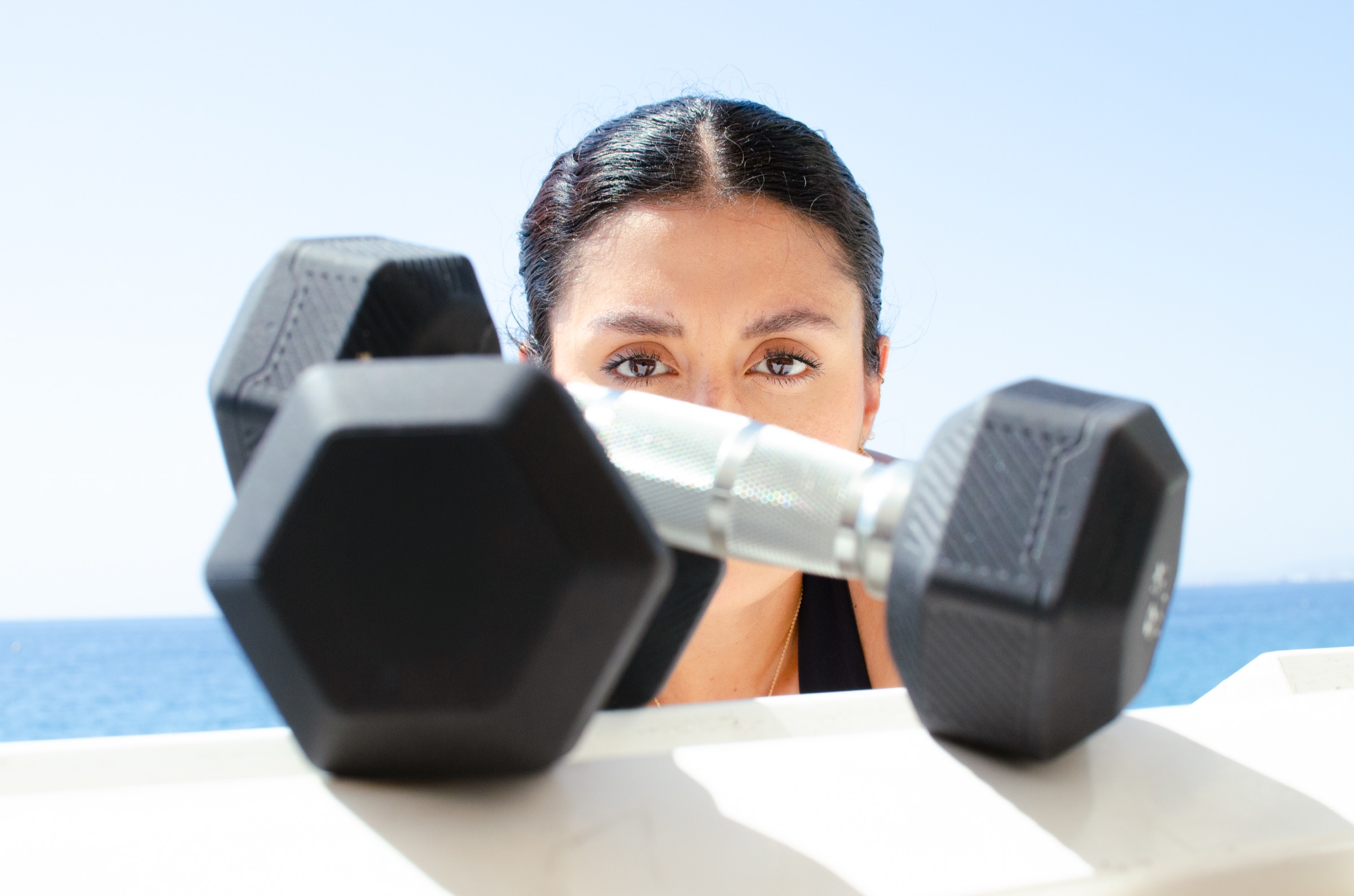 Regard personal trainer derrière haltères